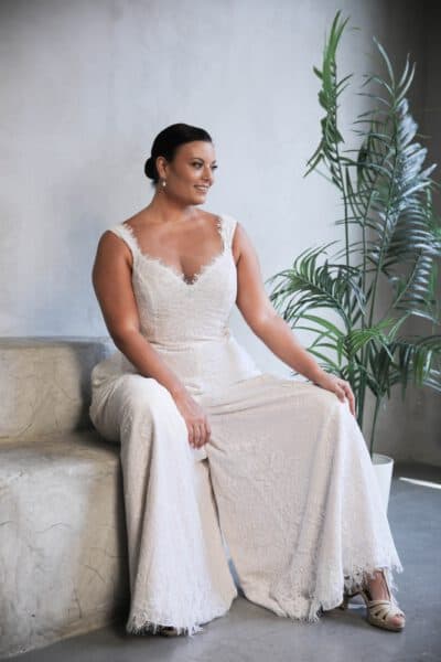 Plus-size bride in a lace bridal jumpsuit with wide-leg pants and a V-neckline