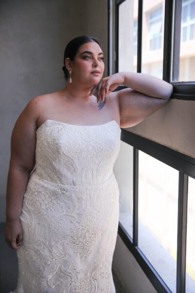 Plus-size bride in a strapless embroidered lace wedding gown with a fitted silhouette