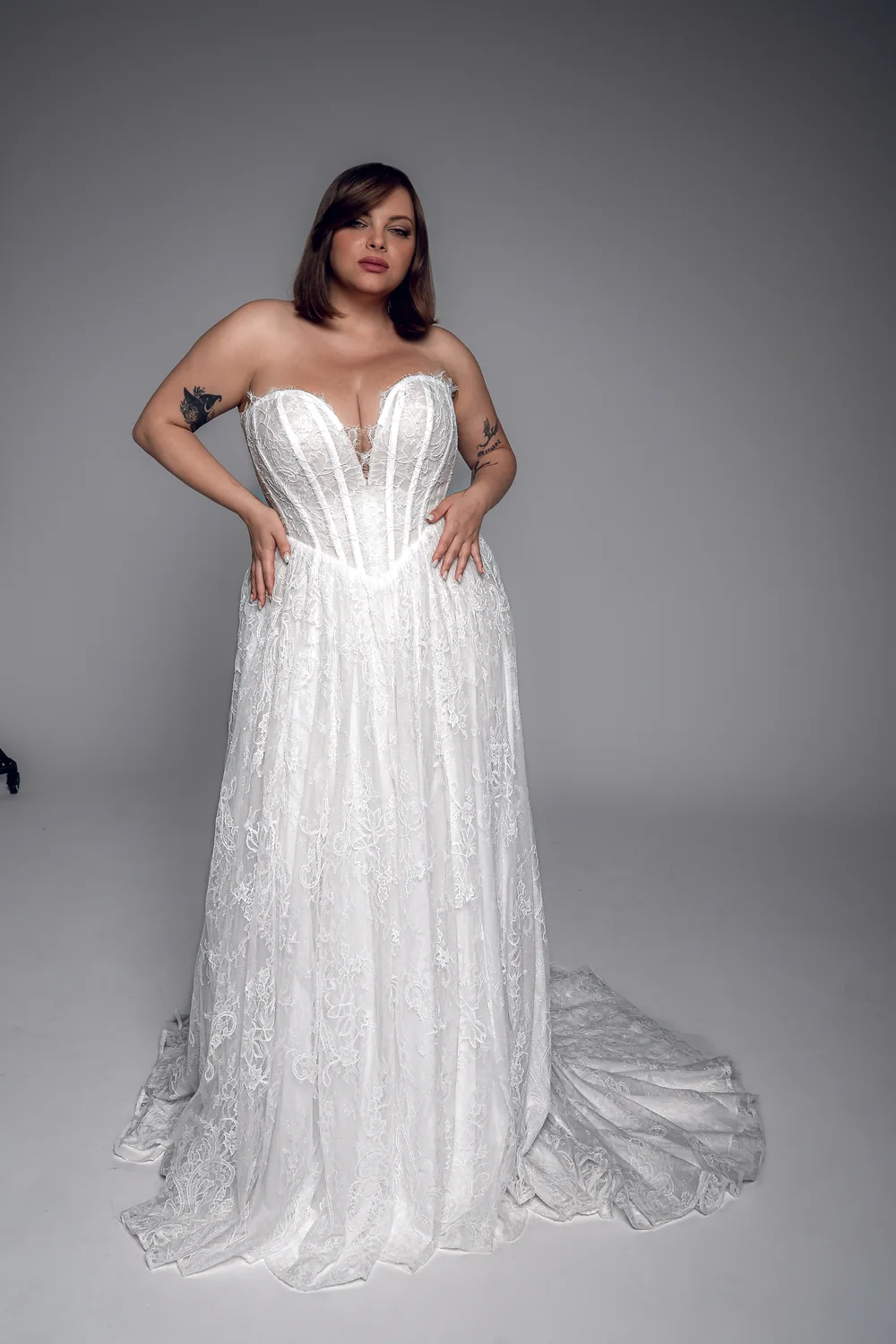 Studio Levana Anaise plus size lace A-line wedding dress with lace fabric and a strapless corset, full-length front view