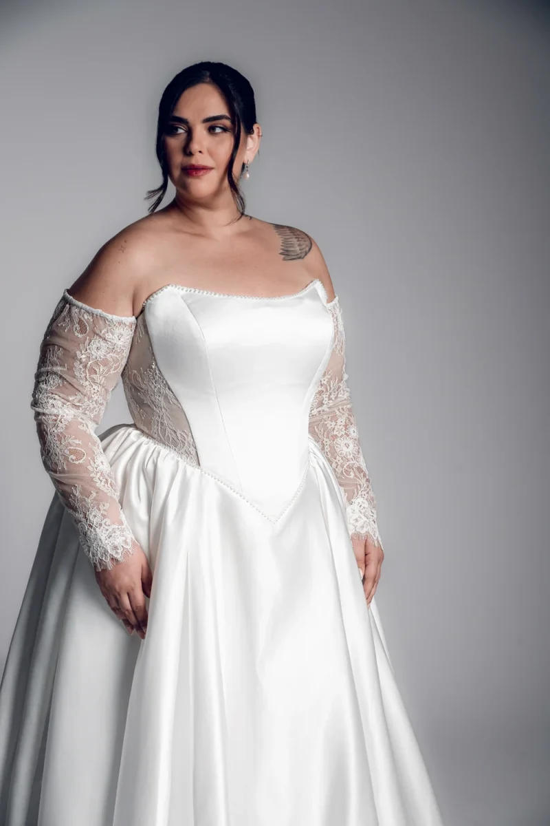 Studio Levana Ines plus size satin A-line wedding dress with satin fabric and long lace sleeves, front three-quarter view