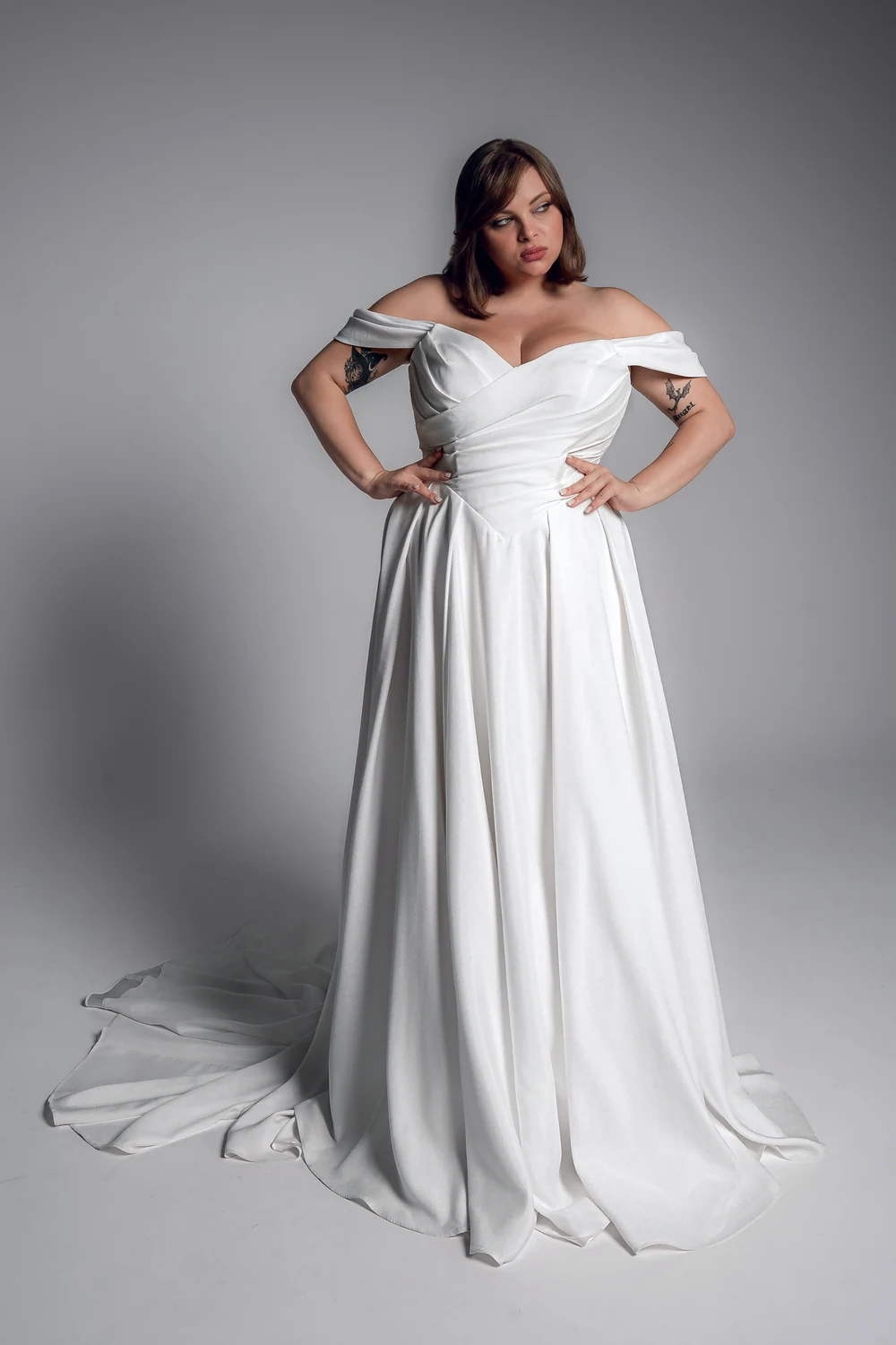 Studio Levana Manon plus size satin A-line wedding dress with draped satin and an off-the-shoulder neckline, full-length front view