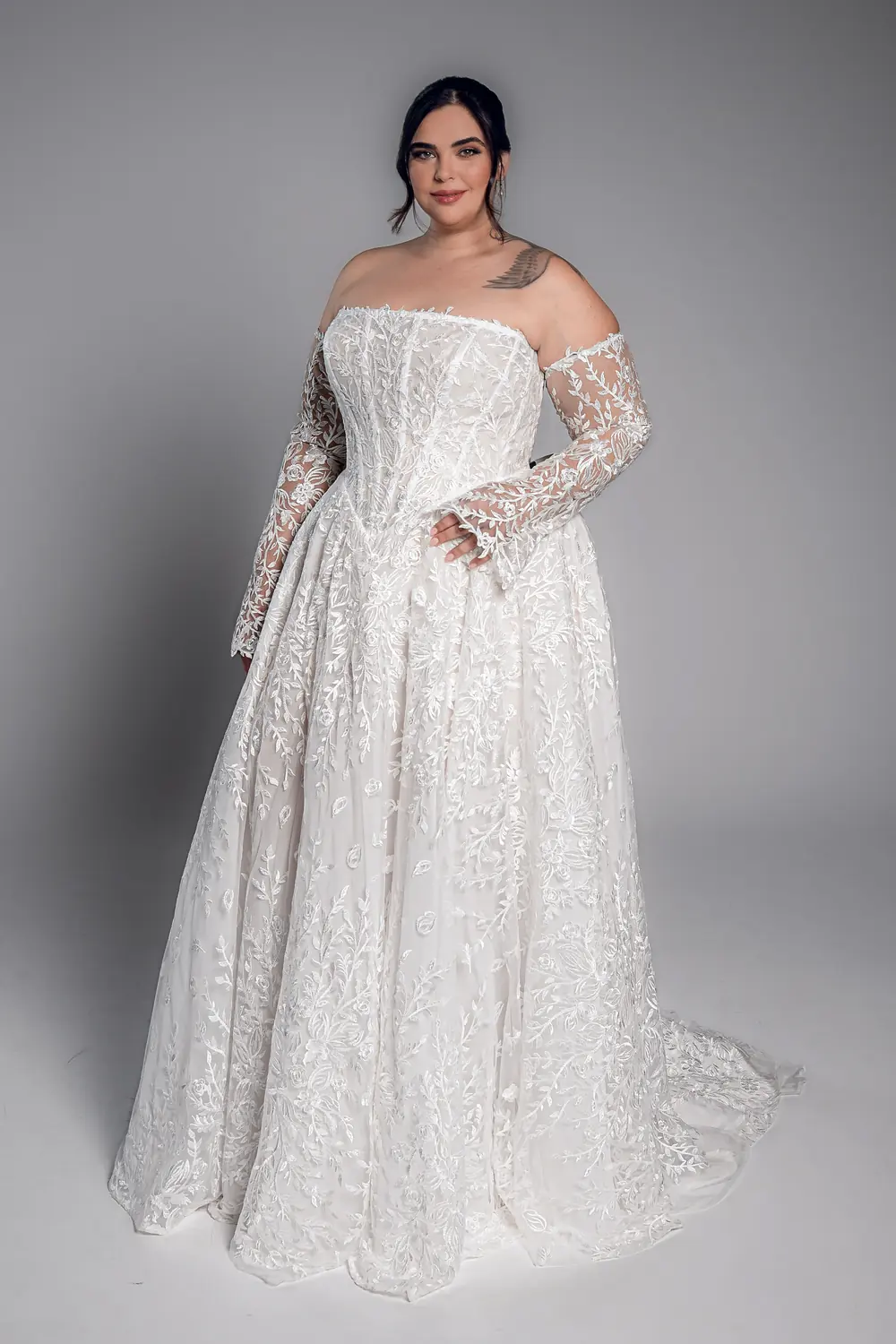 Studio Levana Noemia plus size embroidered lace A-line wedding dress with embroidered lace and an off-the-shoulder neckline, full-length front view