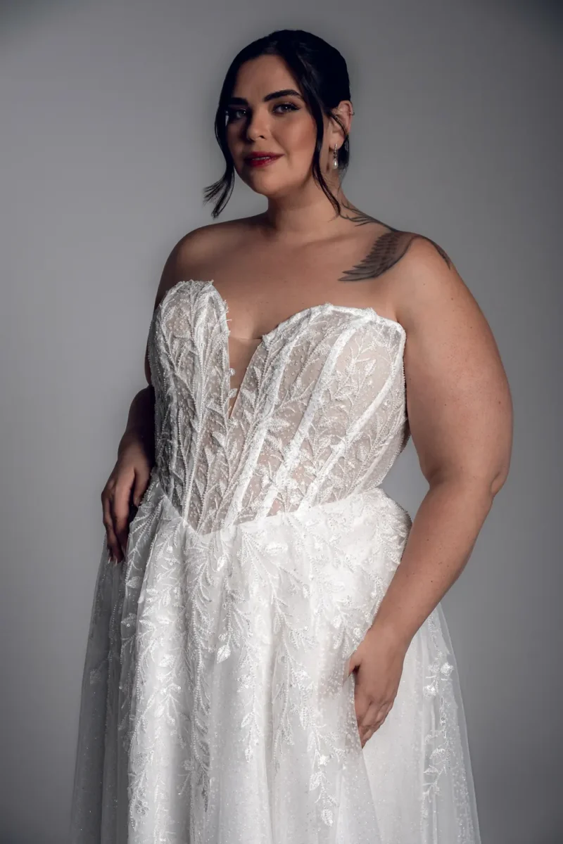 Studio Levana Sheina plus size lace A-line wedding dress with embroidered lace and an off-the-shoulder neckline, close-up detail